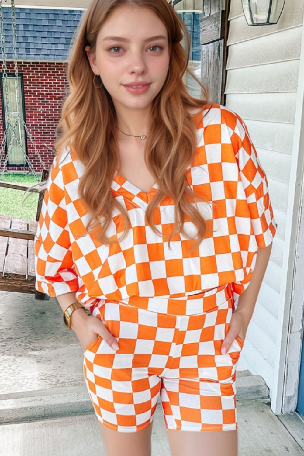Orange and white checkered v-neck top and shorts set with short sleeves.