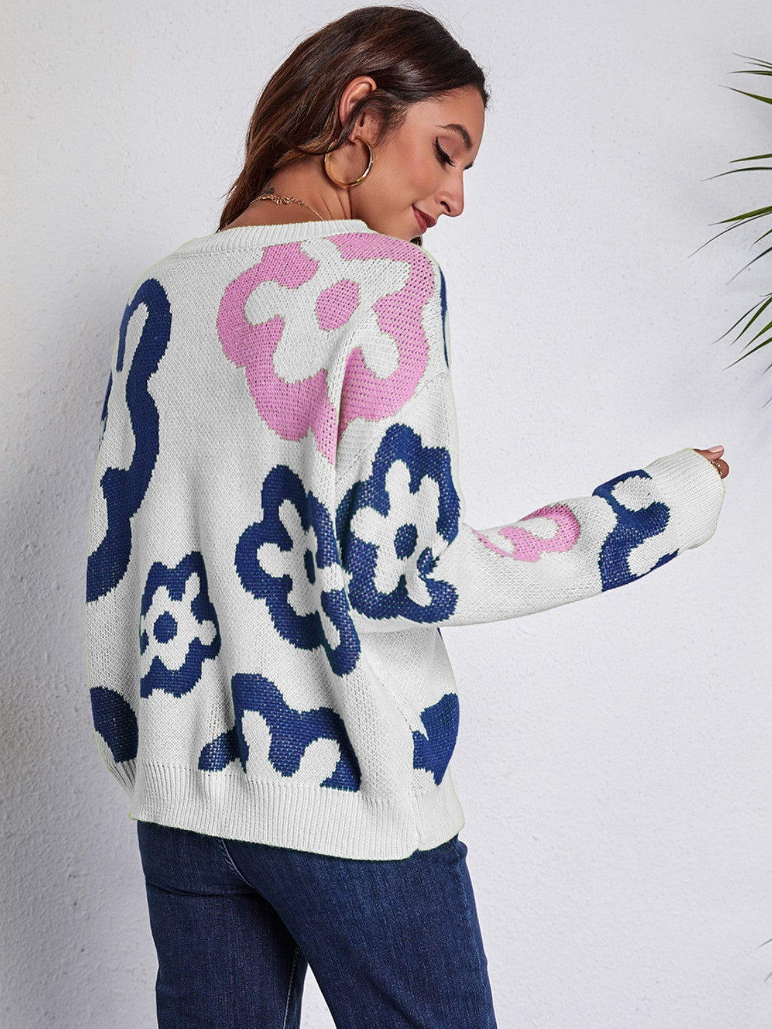 White crewneck sweater with abstract floral pattern in pink and navy blue acrylic knit.