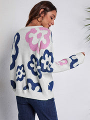 White crewneck sweater with abstract floral pattern in pink and navy blue acrylic knit.