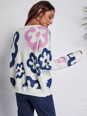 White crewneck sweater with abstract floral pattern in pink and navy blue acrylic knit.