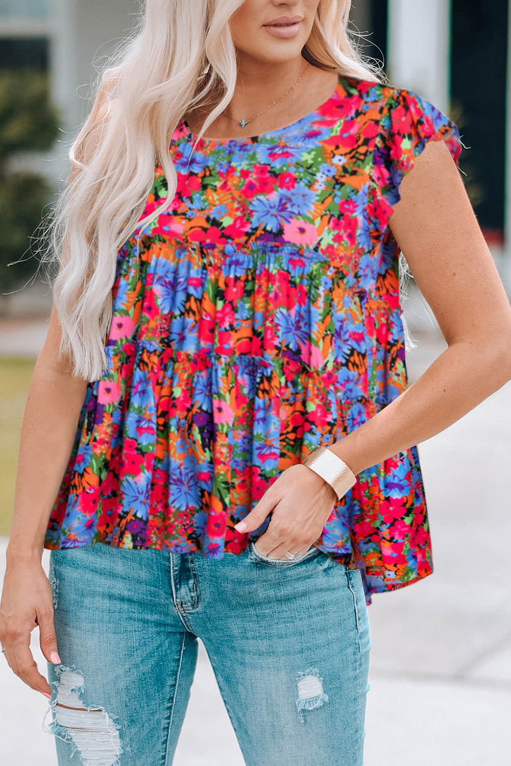 Tiered floral print blouse with flutter sleeves and a babydoll cut in multicolor.