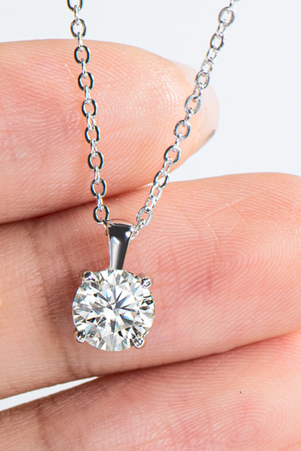 Silver solitaire pendant necklace with a round-cut diamond on a delicate chain.
