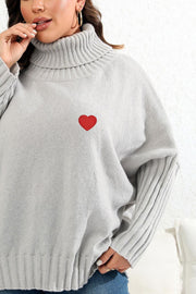 Light gray knit turtleneck sweater with red heart appliqué and ribbed sleeves.