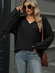 Black ribbed v-neck blouson sleeve top with textured fabric.