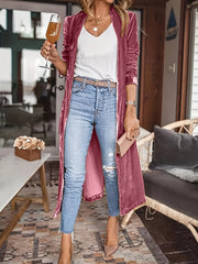 Burgundy velvet duster coat with fluid silhouette, open front, long sleeves, worn with jeans.