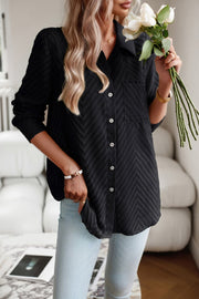 Black textured chevron button-down blouse with a single chest pocket and white buttons.