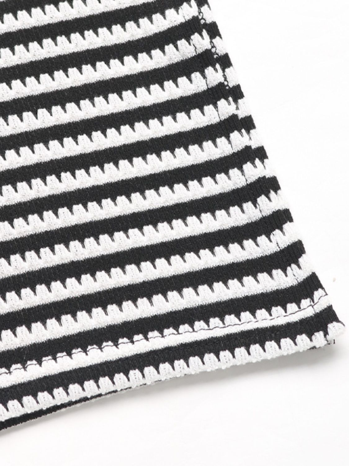 Black and white striped textured knit fabric detail of a halter top and slit skirt set.