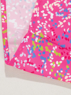 Hot pink blouse with abstract splatter print and mesh sleeves.