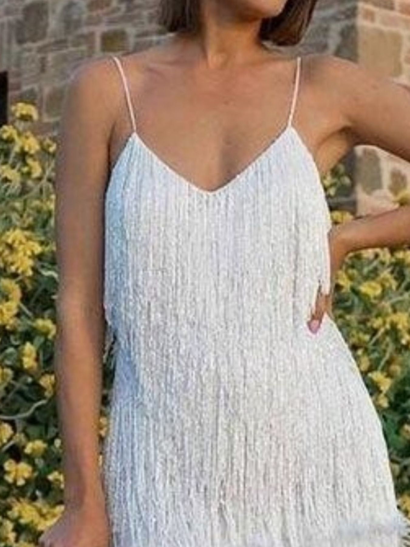 White fringe mini dress with spaghetti straps and V-neckline.