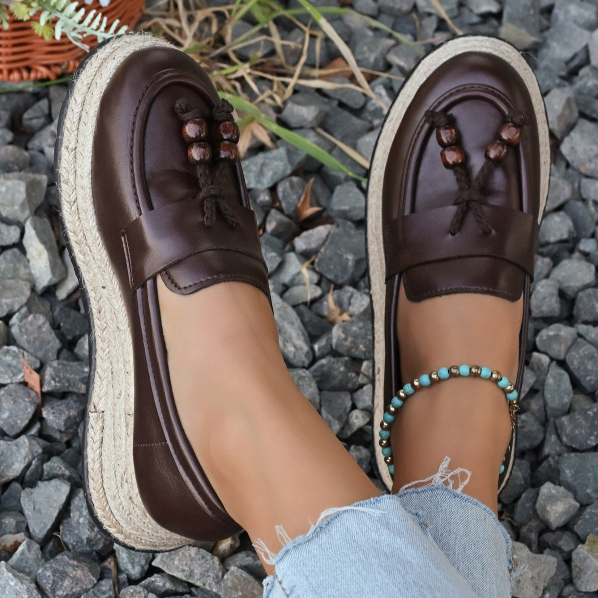 Brown espadrille wedge slip-on loafers with braided jute sole and beaded tassel detail.