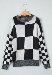 Colorblock checkerboard knit sweater in black and white with a crew neck.
