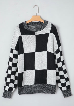 Colorblock checkerboard knit sweater in black and white with a crew neck.
