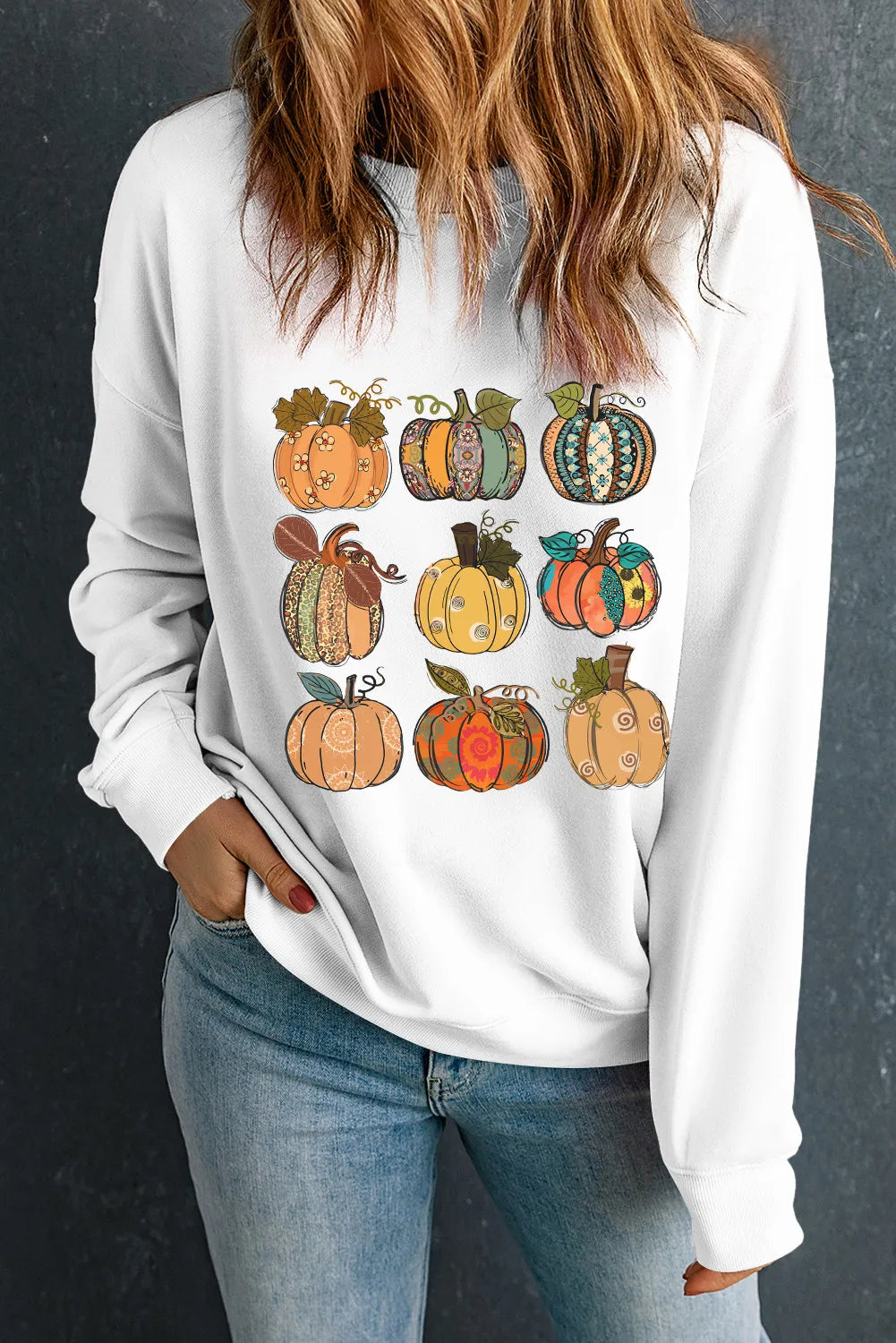 White crewneck sweatshirt with a whimsical pumpkin patch graphic.