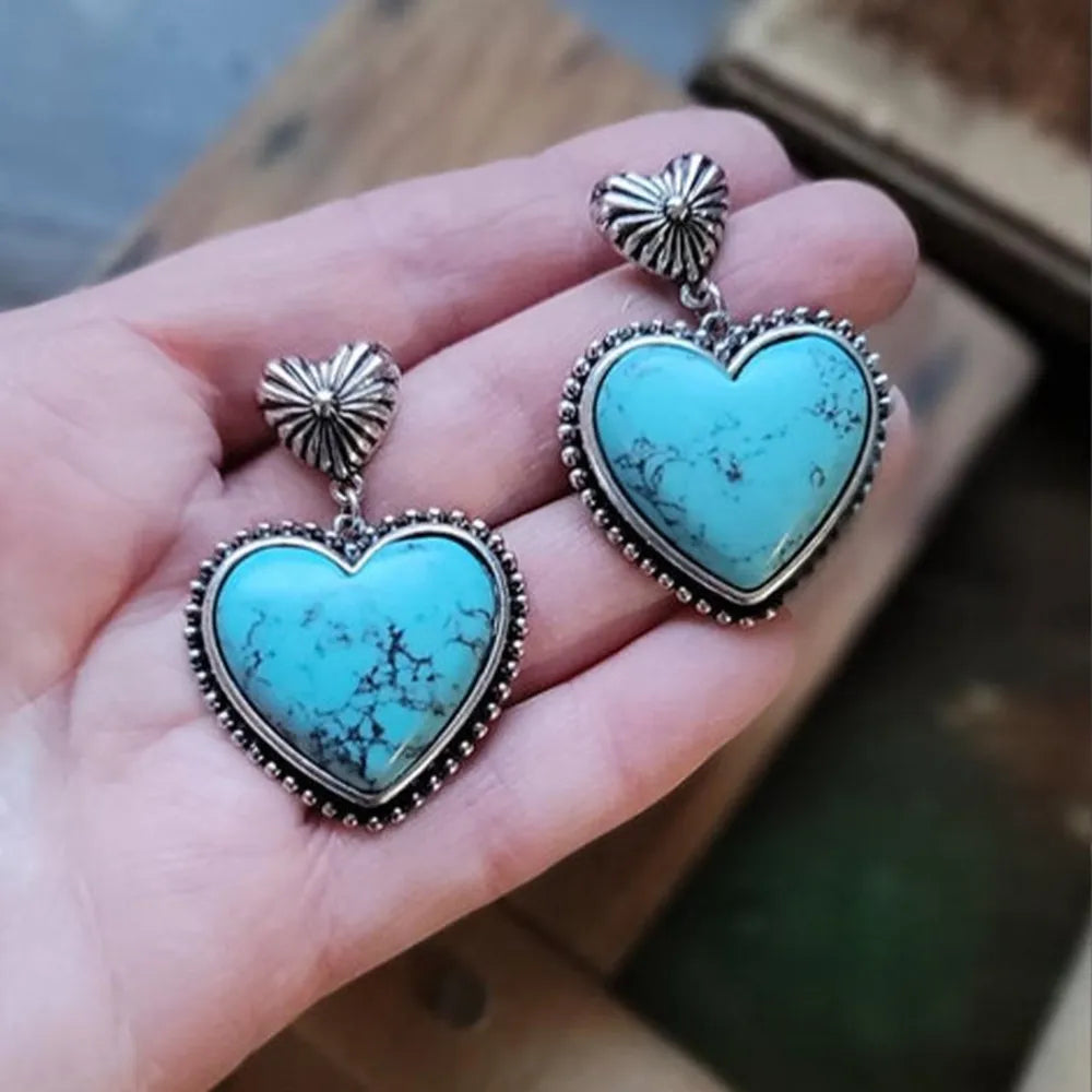 Turquoise heart stone drop earrings with beaded silver trim and sunburst studs.
