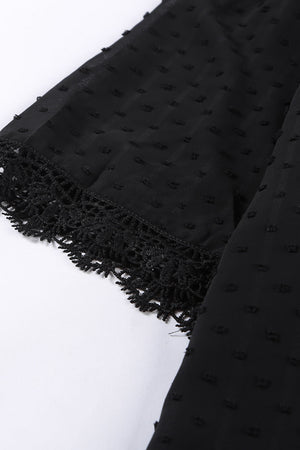 Black textured dot blouse with lace trim detail on sleeve cuff.