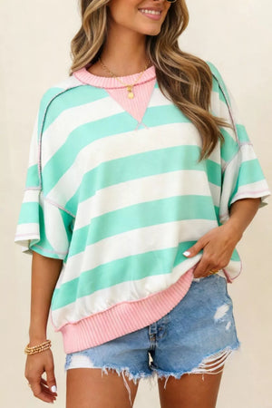 Oversized striped t-shirt with exposed seams, pink neckline and hem, and wide sleeves.