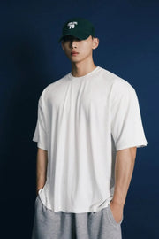 Oversized white crew neck t-shirt with a modern silhouette and short sleeves.