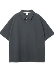 Boxy textured polo shirt in dark gray with a spread collar and two-button placket.