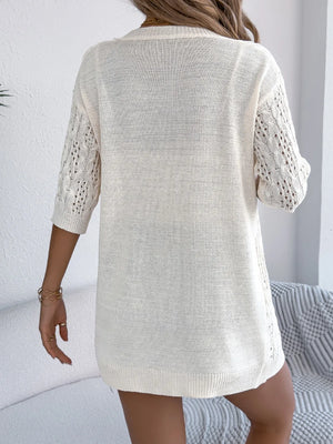 Ivory open-knit three-quarter sleeve cardigan with cable knit detail on sleeves.