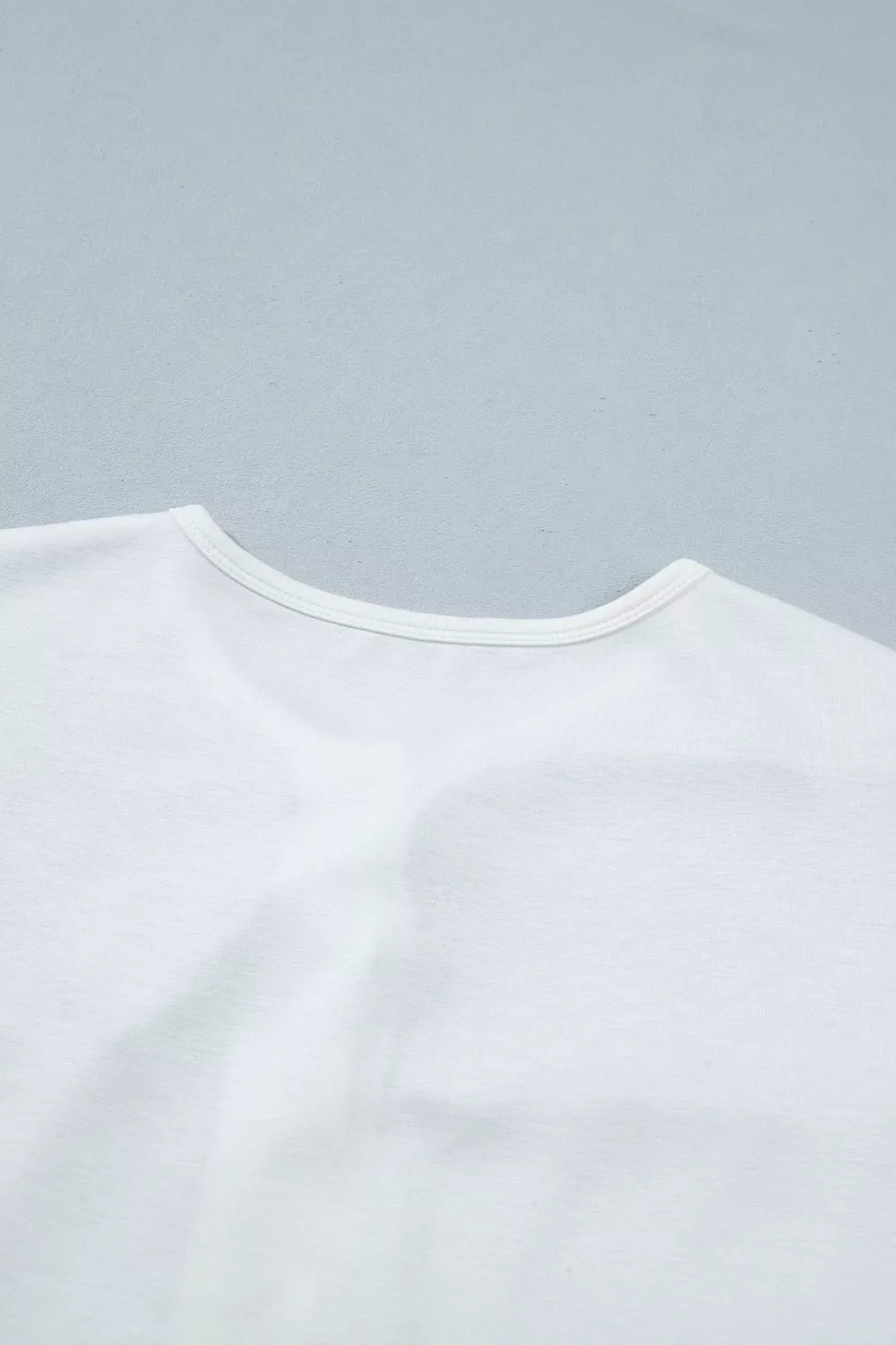 White polyester maternity t-shirt with a round neckline and short sleeves.