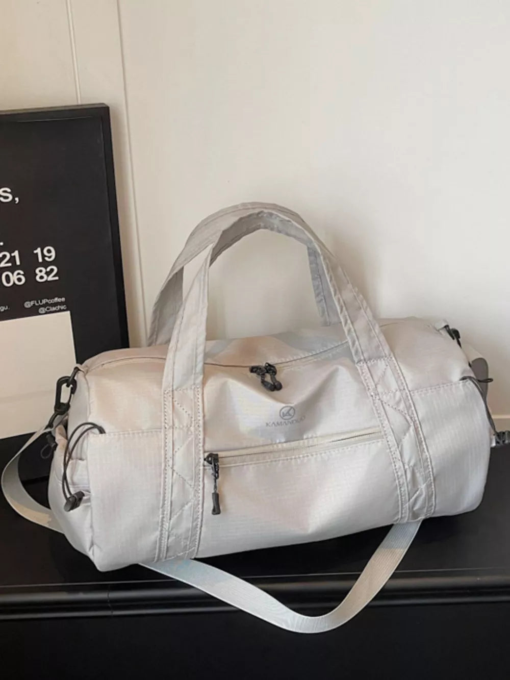 Light gray medium nylon travel bag with multiple zippered pockets and adjustable strap.