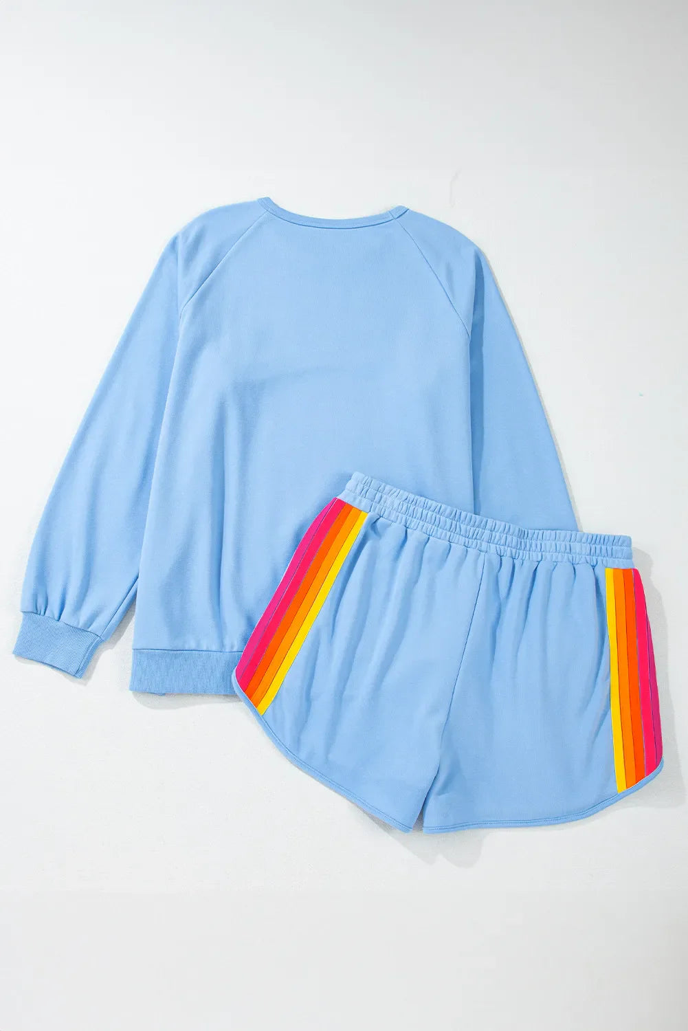 Pastel blue loungewear set with rainbow stripe detail on shorts.