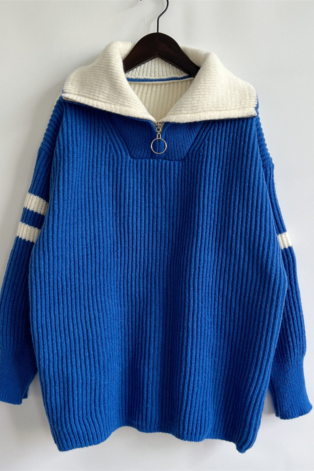 Royal blue ribbed knit quarter-zip sweater with white collar and sleeve stripes.