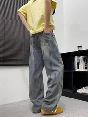 Men's wide-leg denim jeans in blue with paint splatters and graphic details.