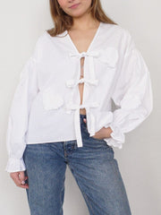 White blouse with heart appliqués and tie front, long puff sleeves with ruffled cuffs.