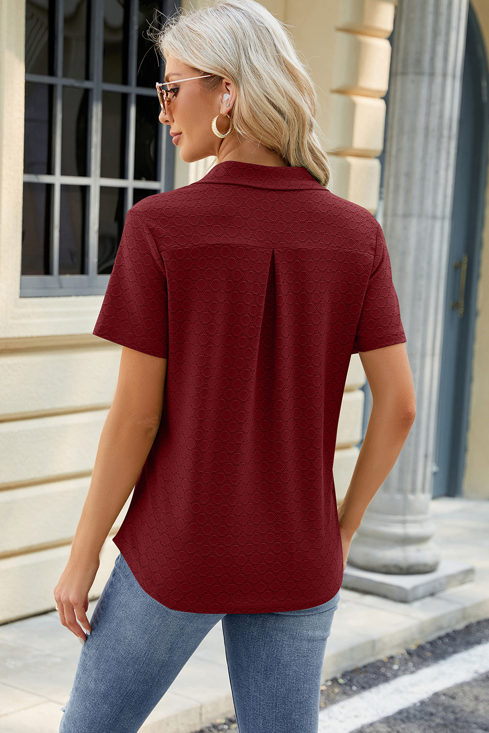 Burgundy textured polo shirt with V-neck detail and short sleeves.