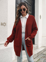 Burgundy ribbed knit cocoon cardigan with pockets and balloon sleeves.