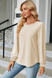 Cream textured puff sleeve blouse with ruffled cuffs and crew neck.