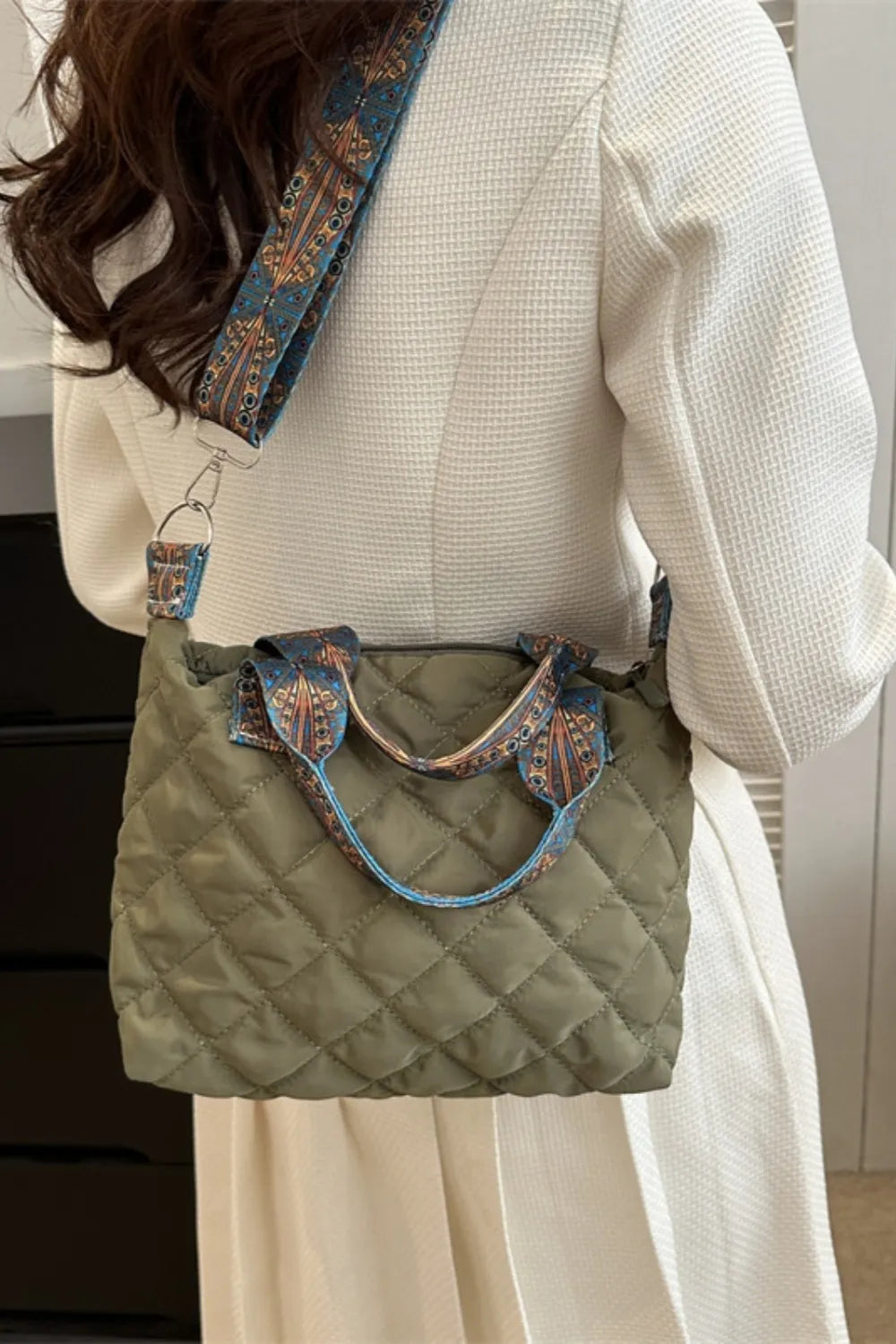 Moss green quilted satchel with patterned strap and top handles.