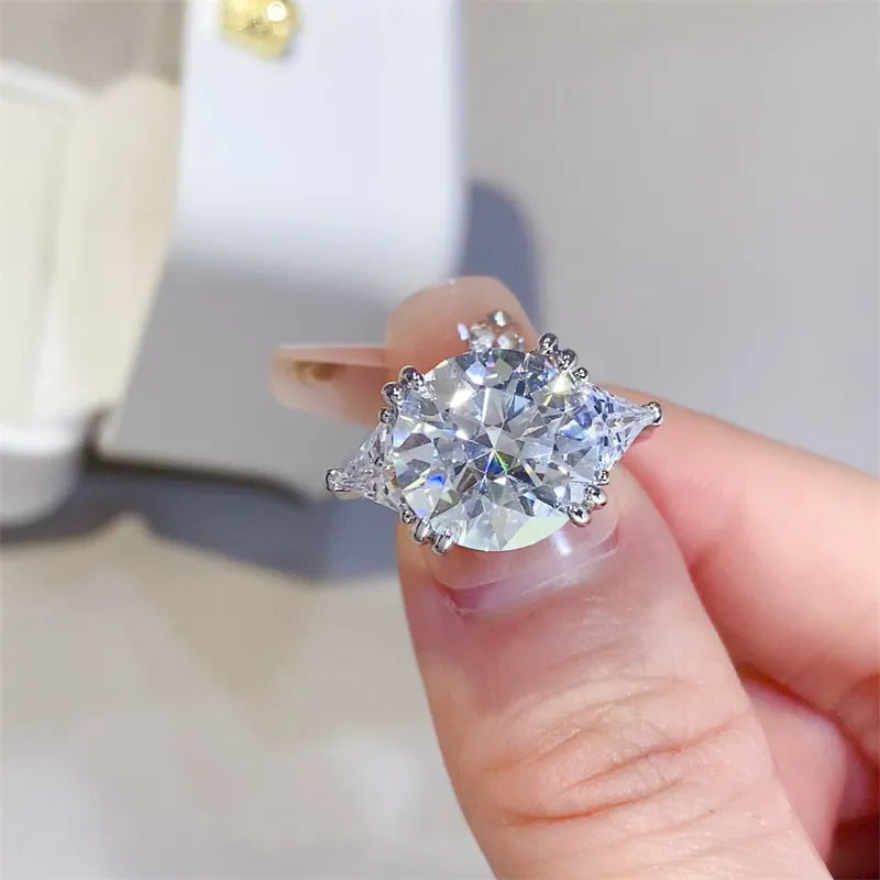 Sterling silver ring with a large, brilliant trillion-flanked moissanite center stone.