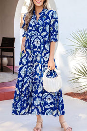 Vibrant floral maxi dress with frilled collar, buttoned front, and tiered skirt.