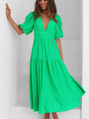 Green midi dress with V-neck, cinched waist, and puff sleeves.