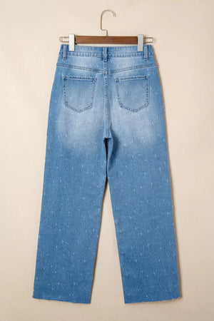 High-rise light wash denim jeans with subtle all-over pattern and raw hem.