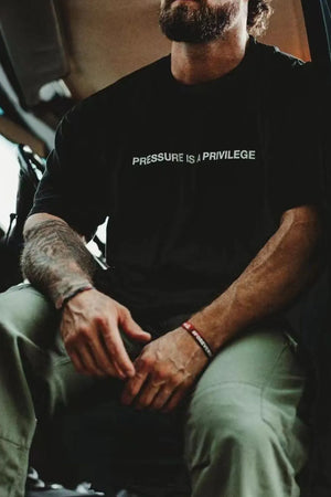 Black graphic tee with white text "PRESSURE IS A PRIVILEGE
