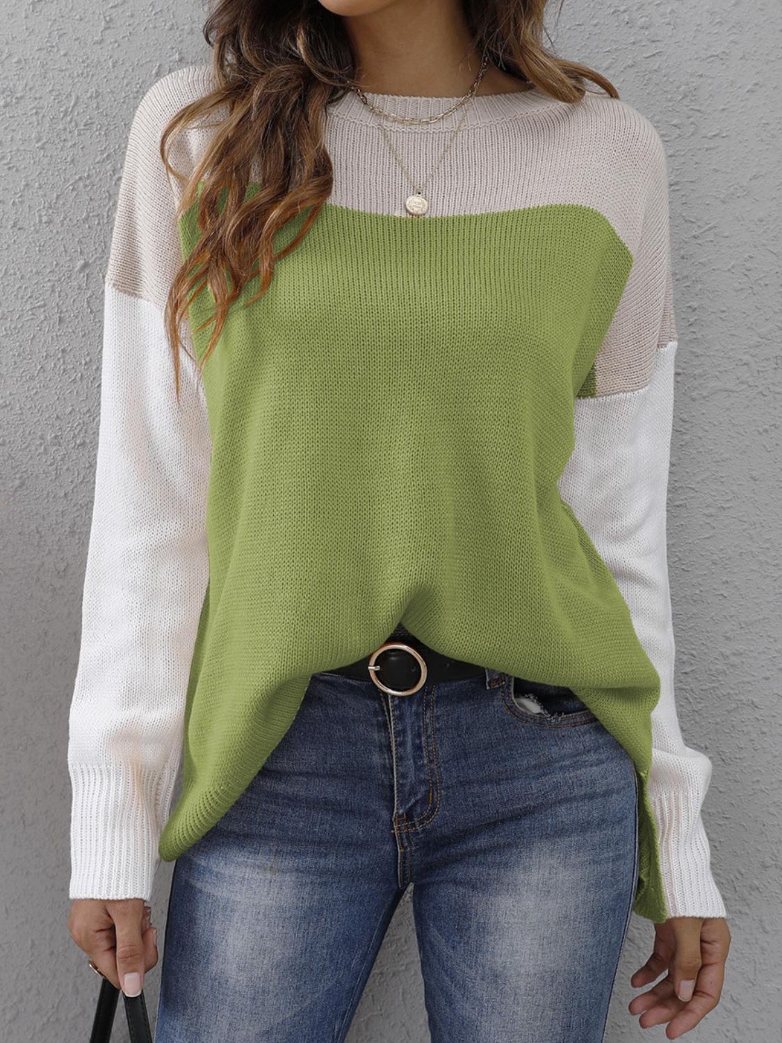 Colorblock crewneck knit sweater in lime green, beige, and white with side slits.