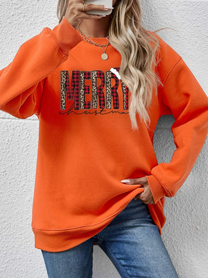 Orange graphic sweatshirt with "Merry Christmas" text in buffalo plaid and leopard print.