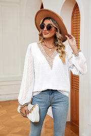 White Swiss dot blouse with V-neck lace trim and poet sleeves.