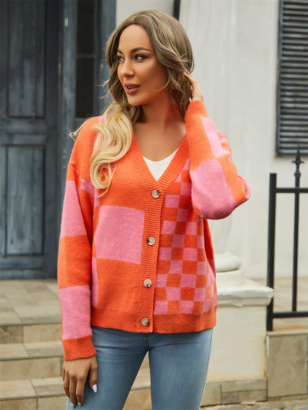 Checkerboard block knit cardigan in orange and pink with button front.