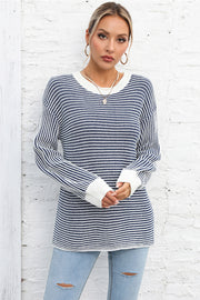 Nautical stripe ribbed knit crewneck sweater in navy and white with white cuffs.