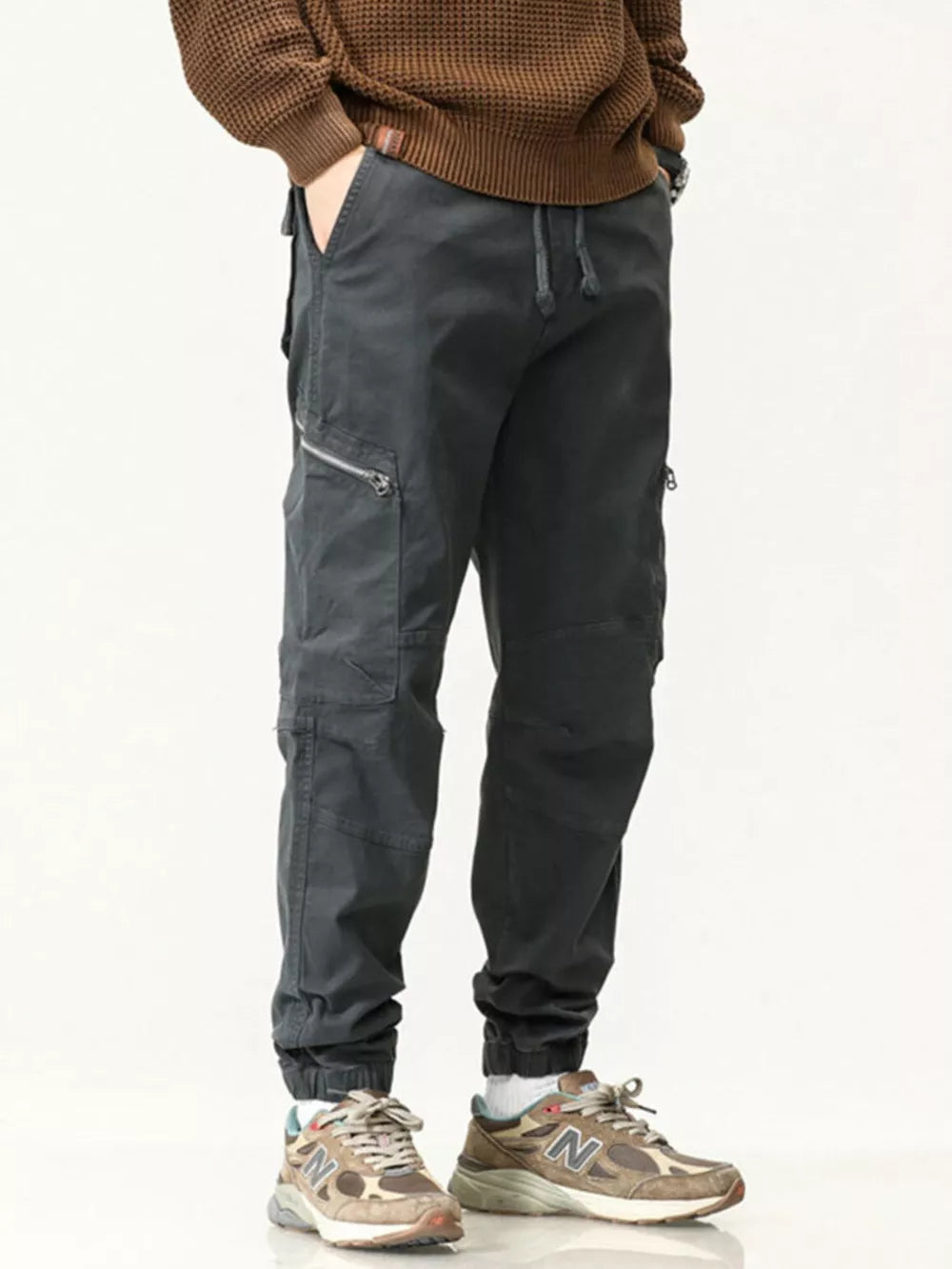 Men's dark gray cotton cargo pants with zipper pockets and drawstring waist.
