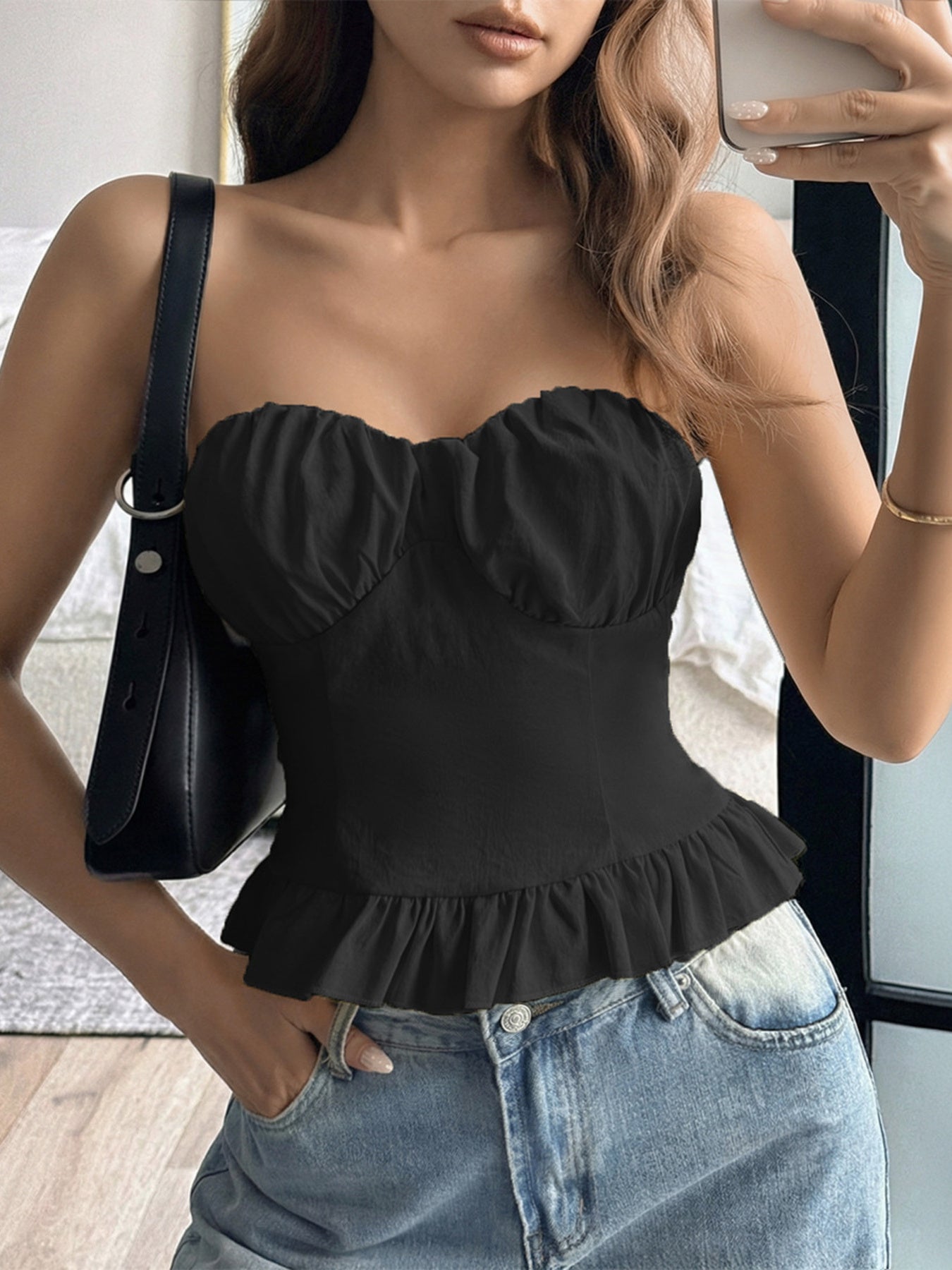Black strapless tube top with ruffled hem and sweetheart neckline.