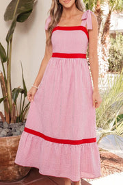 Maxi dress with pink and white stripes, red trim, bow knot straps, and a tiered hem.