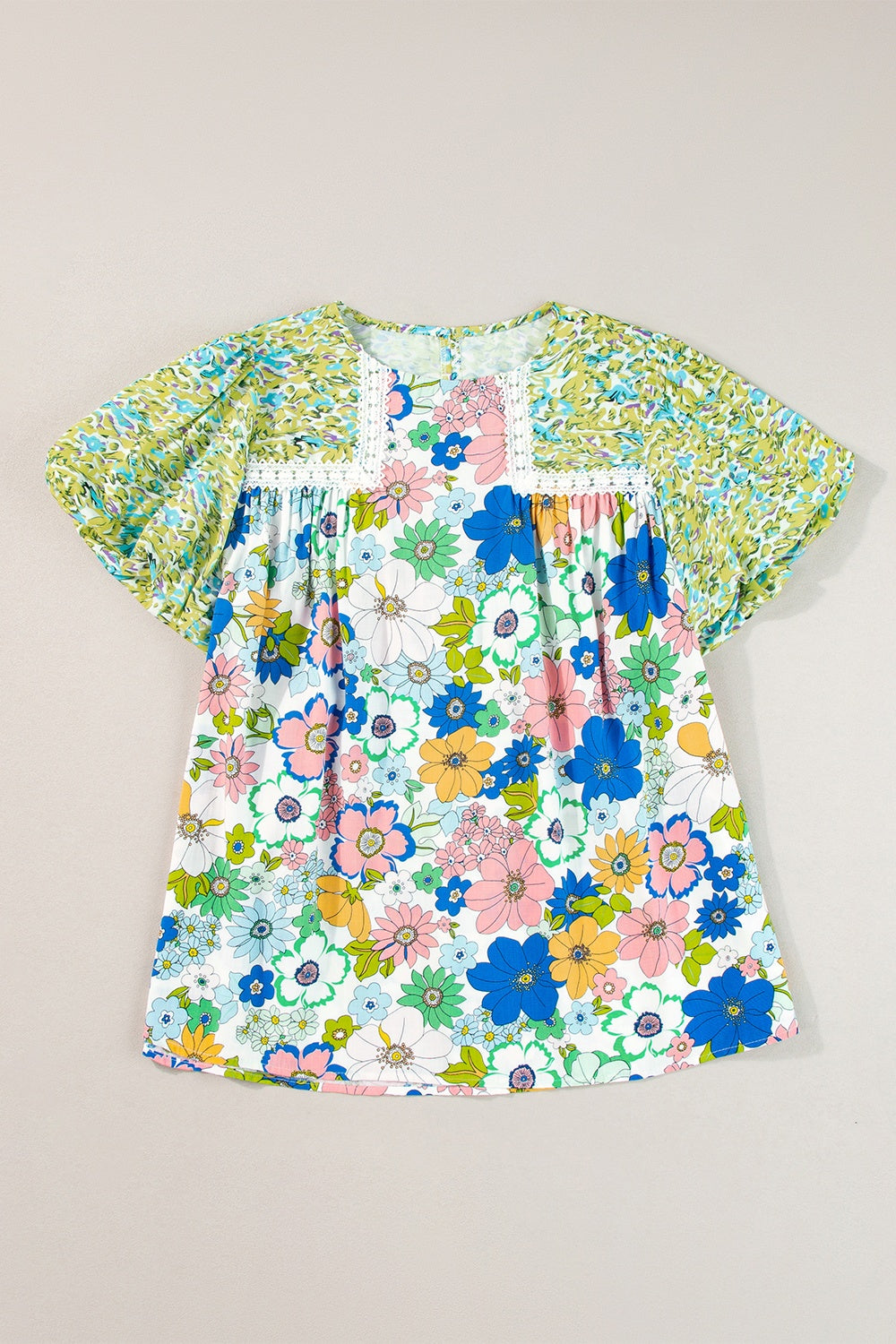 Floral patchwork blouse with puff sleeves and crochet trim, featuring a vibrant floral print in lime and cerise.