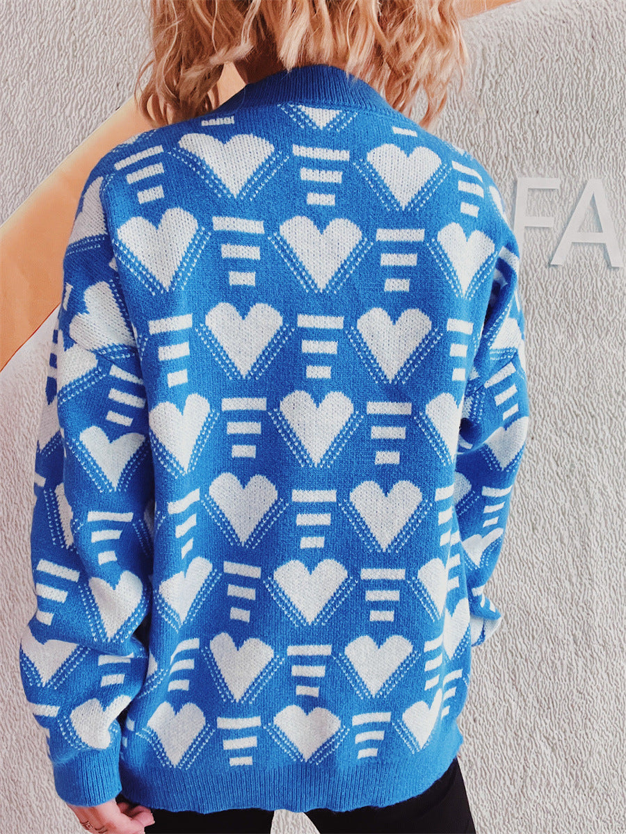 Blue acrylic knit jumper with white geometric heart pattern, crew neck, long sleeves.