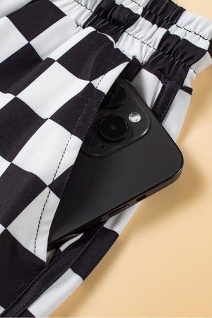 Black and white checkerboard lounge shorts with a phone in the pocket.