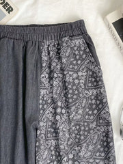 Black comfort jeans with elastic drawstring waist and bandana print panel.